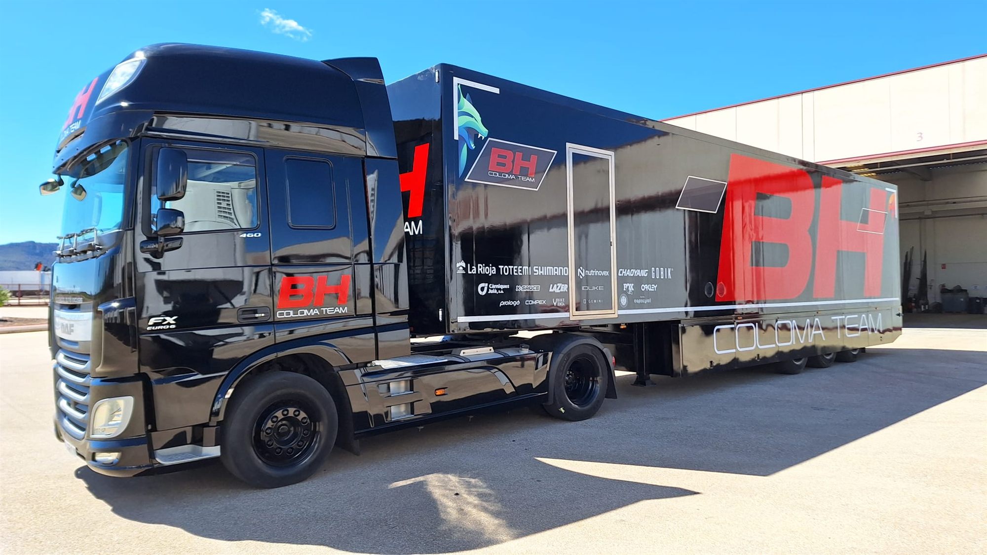 Cabeza tractora y tráiler negros con el cielo reflejado en la chapa